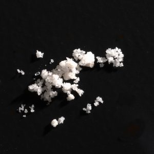 Close-up view of 4-AcO-DMT powder on a clean surface, showcasing its fine crystalline texture.