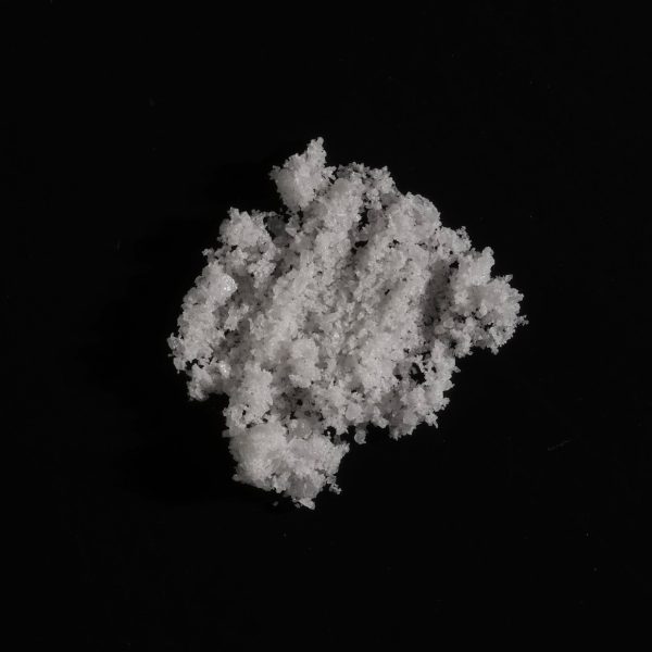 Close-up view of 5-MeO-αMT in a fine powder form, displayed on a clean, flat surface under neutral lighting