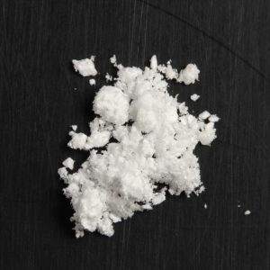 Close-up of 5-MeO-DiPT powder on a flat surface, highlighting its fine crystalline texture and purity.