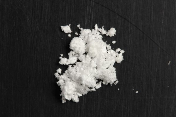 Close-up of 5-MeO-DiPT powder on a flat surface, highlighting its fine crystalline texture and purity.