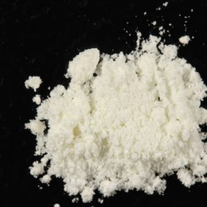 High-quality 5-MeO-MiPT powder displayed on a surface, showing the fine crystalline texture of the synthetic tryptamine compound, commonly used for research and psychedelic experiences.