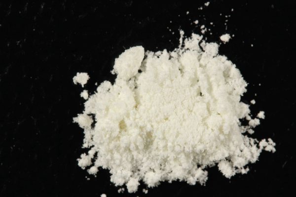 High-quality 5-MeO-MiPT powder displayed on a surface, showing the fine crystalline texture of the synthetic tryptamine compound, commonly used for research and psychedelic experiences.